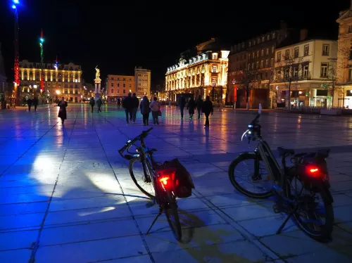 2 vélos de nuit sur la place de Jaude éclairée en couleurs